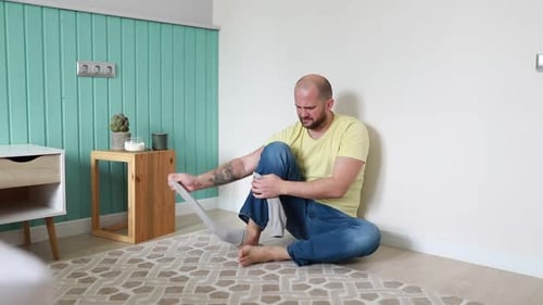 Man Removing Sock and Showing Displeasure