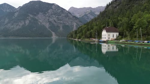 Early morning over Lake in Tyrol Austria clear still water drone aerial view 4K