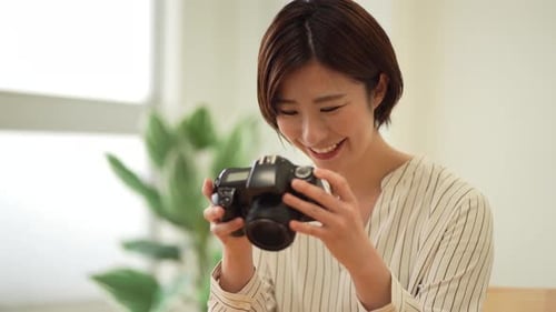 Woman Smiling while Looking at Images on Camera
