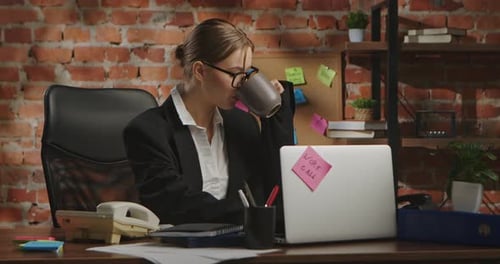 Young Businesswoman in Office with Brick Wall Background
