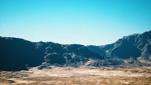 Aerial View Over Arid Mountain Landscape with Blue Sky