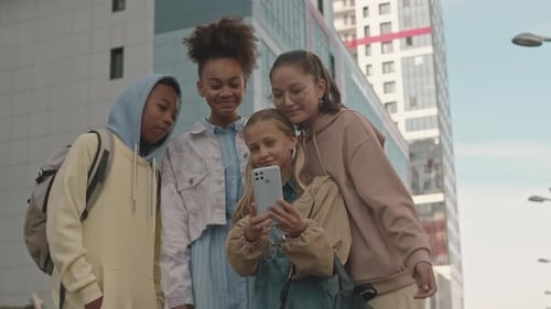 Children Gathered Around a Phone in City