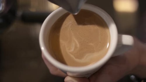 Pouring Milk Into Coffee To Create Latte Art