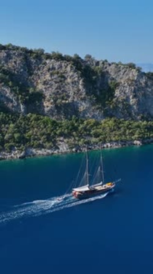 Vertical drone shot of gulet cruising at sea