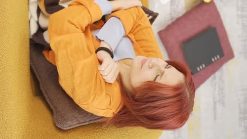 Woman Smiling While Using Phone on Sofa