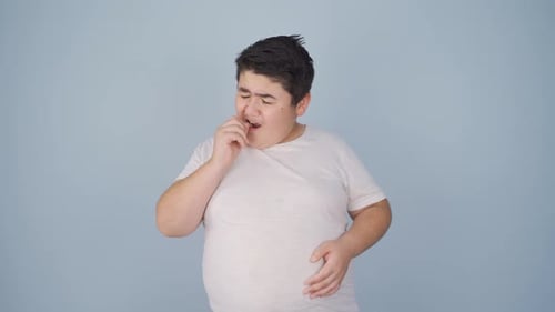Boy Coughing and Covering Mouth on Blue Background