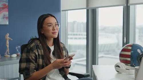 Hipster Girl Pondering Cellphone at Bright Room Closeup