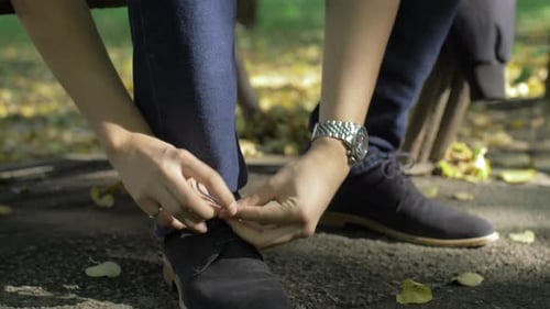Male tying shoelaces park outdoor along ready to go
