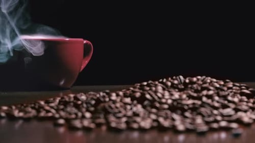 Heiße Kaffeetasse unter gerösteten Kaffeebohnen