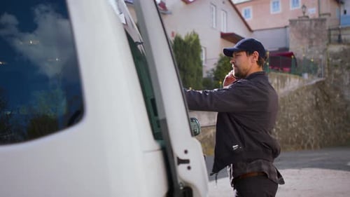 Delivery Man Courier Delivering Parcel Box In Town Using Smartphone.