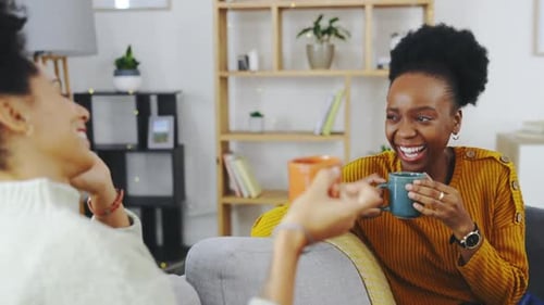 Coffee, conversation and girl friends laugh on a living room sofa at home talking in the lounge