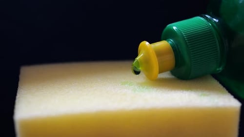Green Dish Soap Poured on a Yellow Sponge