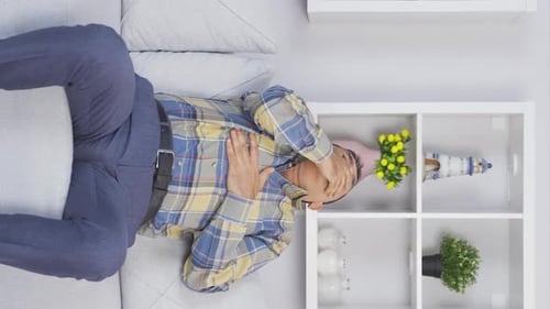 Vertical video of Old man with nausea.