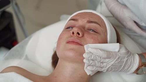Primer plano de una esteticista limpiando la cara de una niña