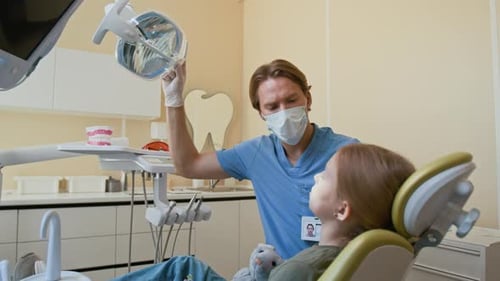 Male Dentist Preparing to Examine Girl