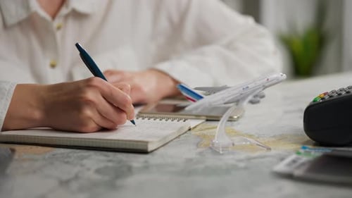 Woman Planning Vacation Trip, Writing in Notepad