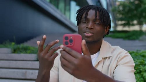 Smiling Man Video Calling on Phone Outdoors