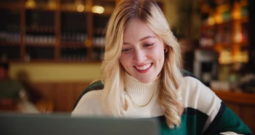 Remote work, smile and woman with laptop in restaurant for freelance job