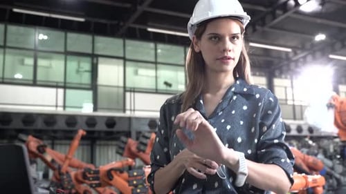 Female engineer at factory. Smart Industry Robot Arms Modernization for Digital Factory Technology