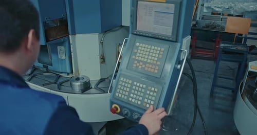 Engineer Stands at the Control Panel of a Conveyor with Metal Products for Aviation