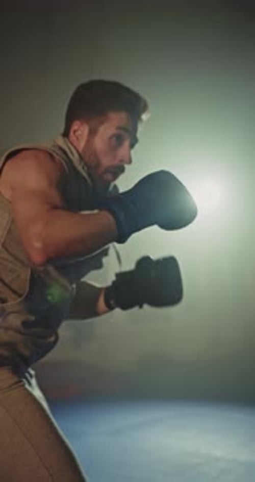 Focused Boxer Training with Gloves in Dark Studio