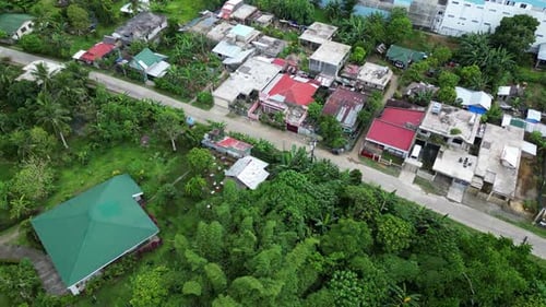 Aerial panoramic view of quiet southeast asia roadway with buildins nestled in trees
