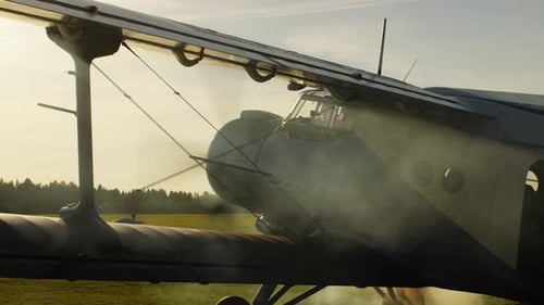 Vintage Biplane Propeller Spinning on Grassy Airstrip
