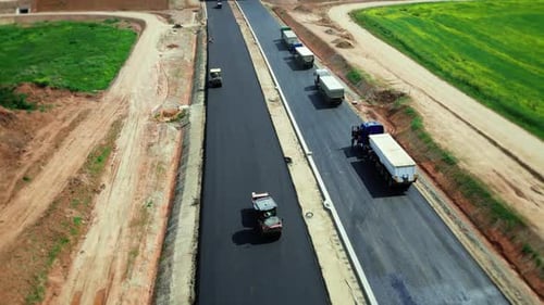 Aerial view of road construction. Asphalt pavers lay asphalt at construction site of a new highway
