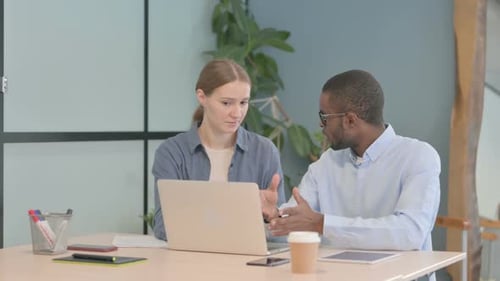 Colleagues Discussing Business at Desk in Office