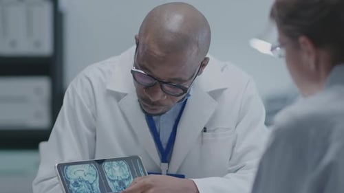 Doctor Discussing Brain Scans With Another Doctor