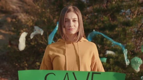 Serious Young Woman Activist Holding Encouraging Green Poster Save the Planet Standing at Landfill