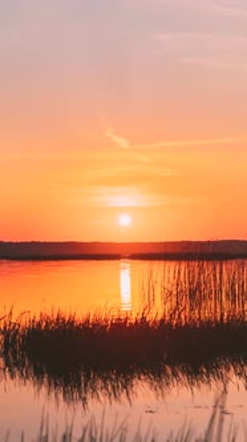 Vertical Shot Sundown Above Lake River Horizon At Sunset