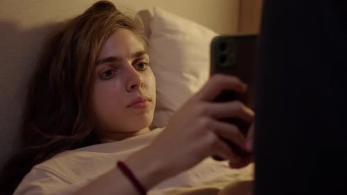 Woman in Bed Using Mobile Phone at Night