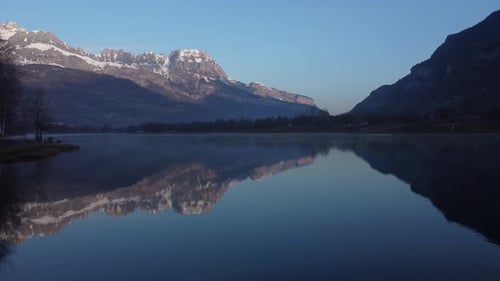 Nice reflections of the mountains on the Passy lake. Aerial shot early morning.