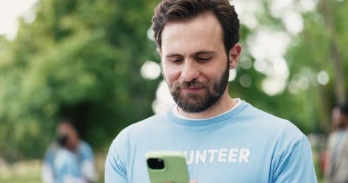 Laughing, phone and volunteer man in park for charity, community outreach or donation update