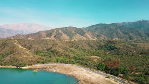 Aerial drone flying over a blue water lake with mountains landscape