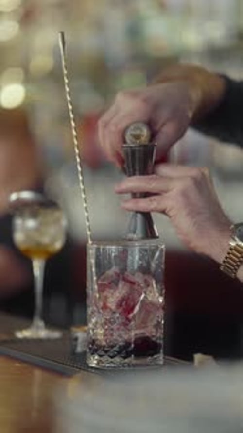 Le barman prépare une portion de whisky à l'aide d'un doseur pour préparer un cocktail.