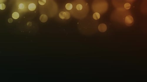 Glamour Collection: Golden orange flickering bokeh falling from top with copy space on a dark backgr