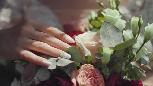 Woman's Hand Touches Wedding Flower Bouquet Close Up