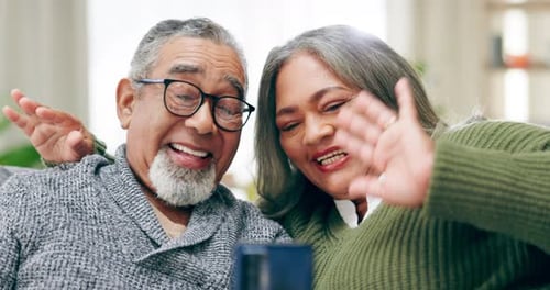 Senior Couple Waving and Smiling at Smartphone