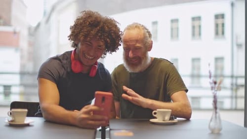 two male friends doing a video call at restaurant coffee bar