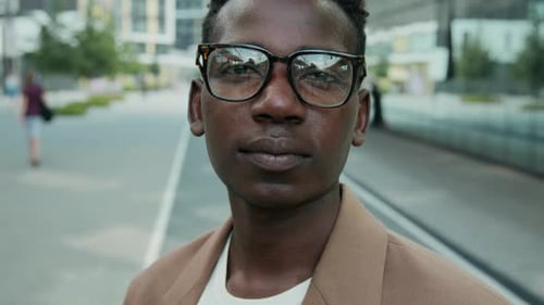 Close-up Portrait of Black Young Man Looking at Camera in City Street