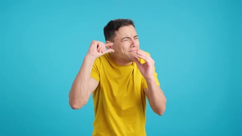 Homem gesticulando uma pequena quantidade com os dedos