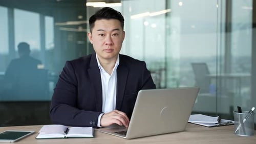 Professional Man Working On Laptop in Modern Office