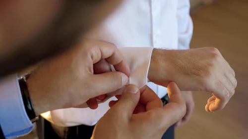 Man Getting Cufflinks Fastened on White Dress Shirt