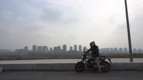 A motorcyclist is starting his motorcycle