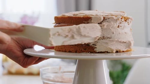 Cake Decorating with Pink Icing in Kitchen Setting
