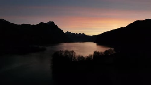Pastel dawn at Walensee, silhouetted Churfirsten. Switzerland aerial view