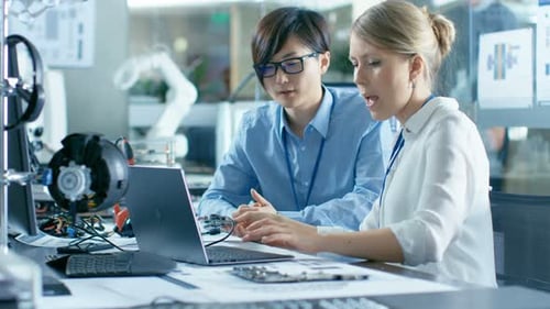 Engineers Collaborating on Circuit Board, Science and Technology