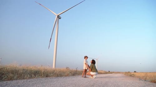 Happy Woman Mother Child Girl Walking Dancing Spinning Turn Around in a Wind Farm